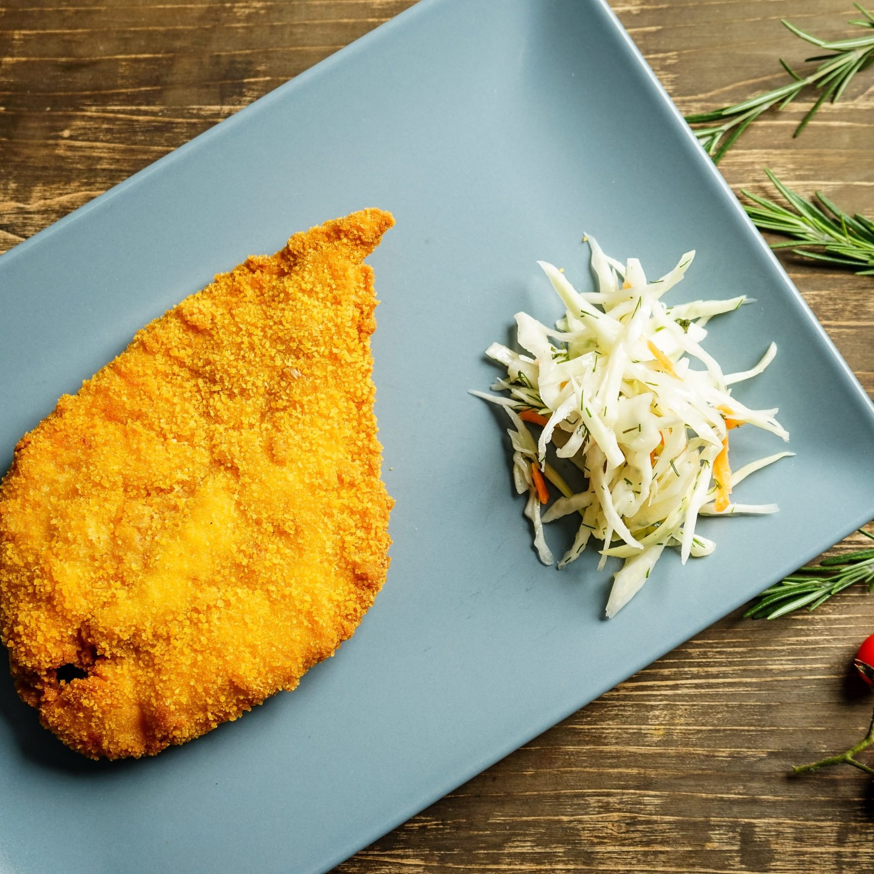 Schnitzel served on blue plate. Top view
