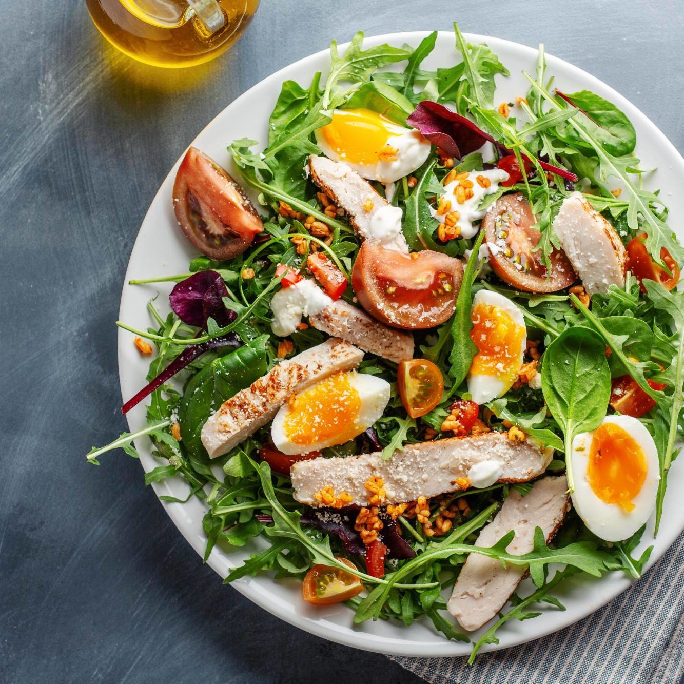 Tasty appetizing salad with turkey, eggs, bulgur and vegetables served on plate. Closeup.